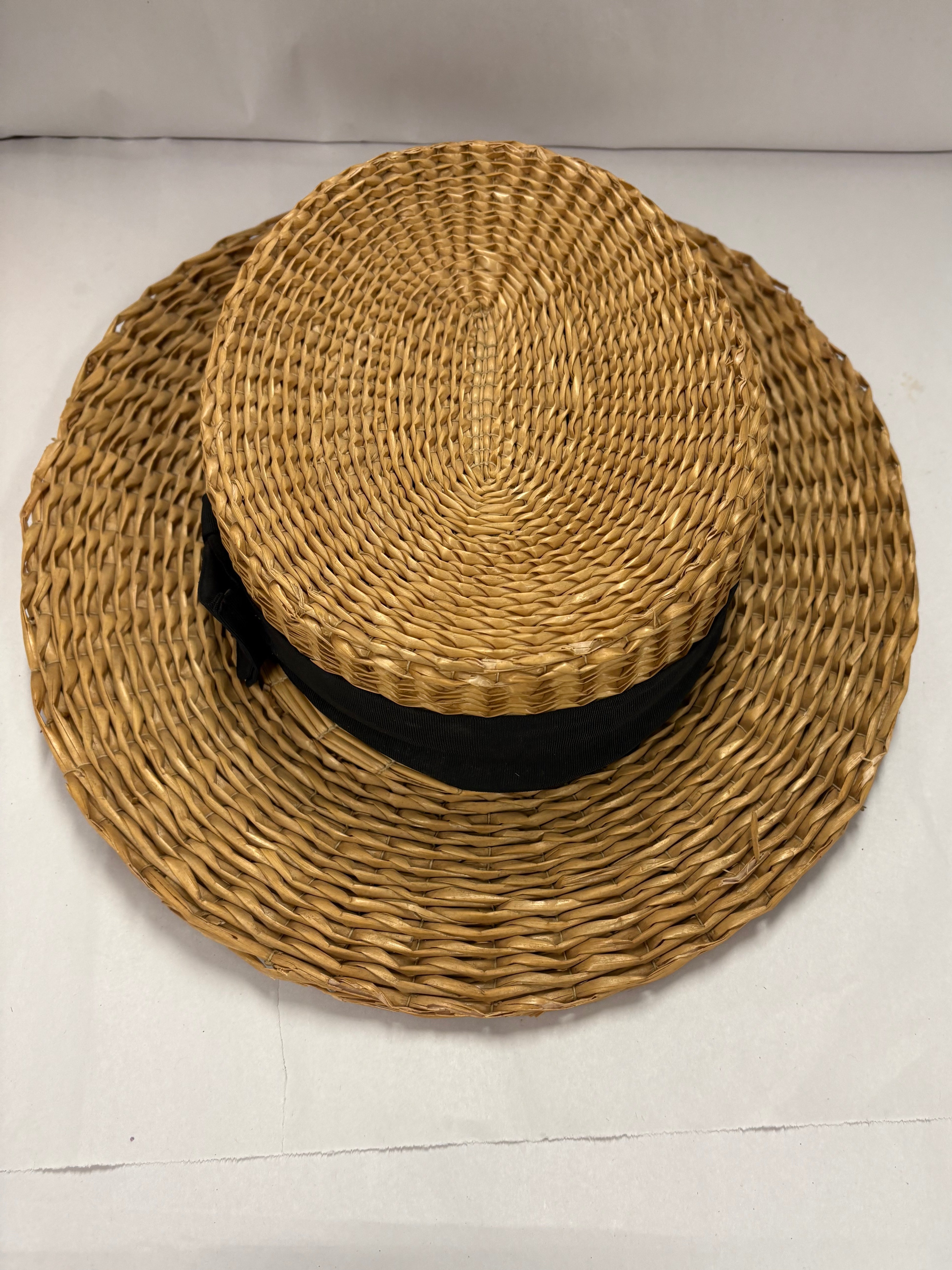 Antique straw boater hat with a black band and bow