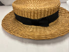 Antique straw boater hat with a black band and bow