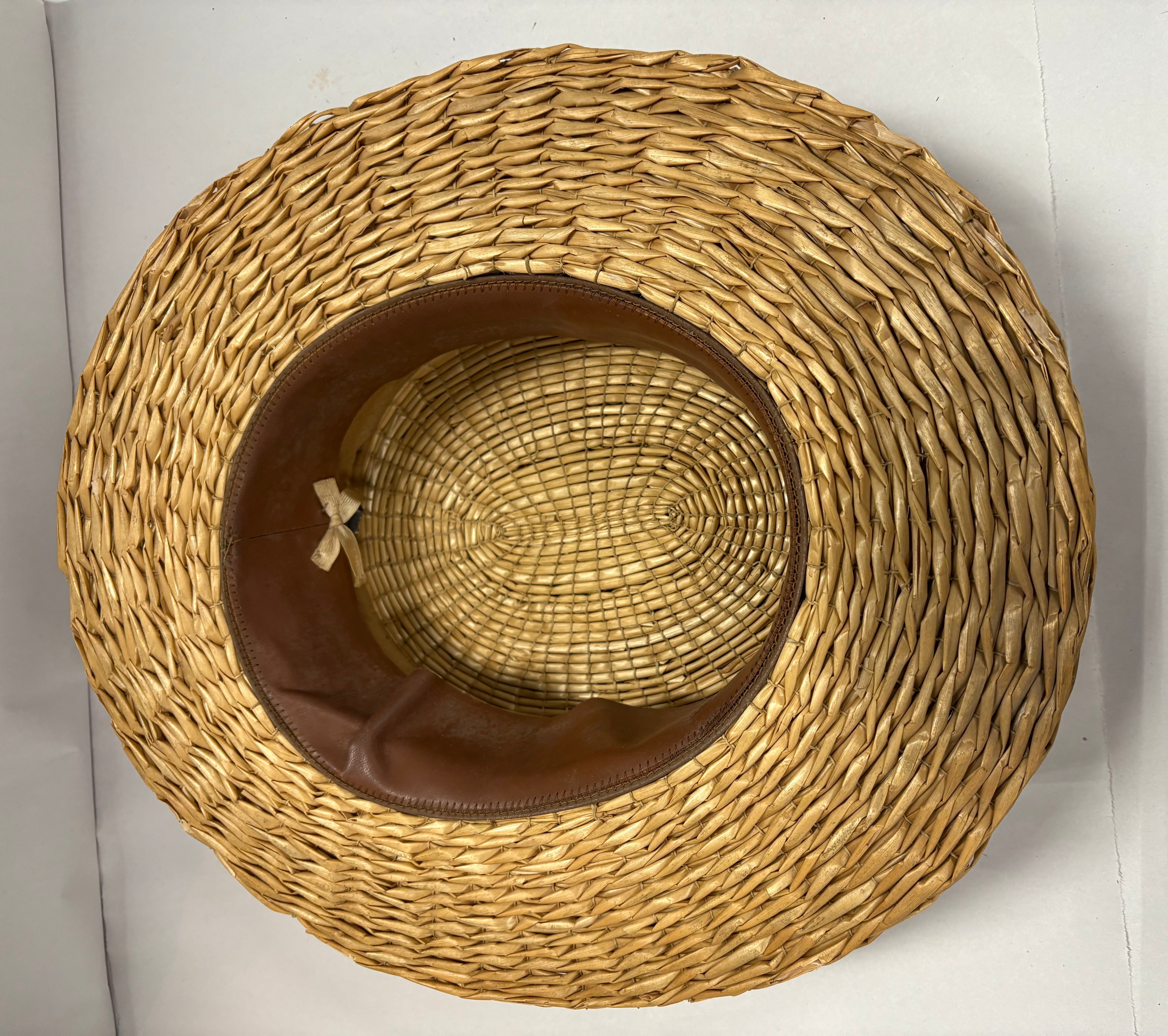 Antique straw boater hat with a black band and bow