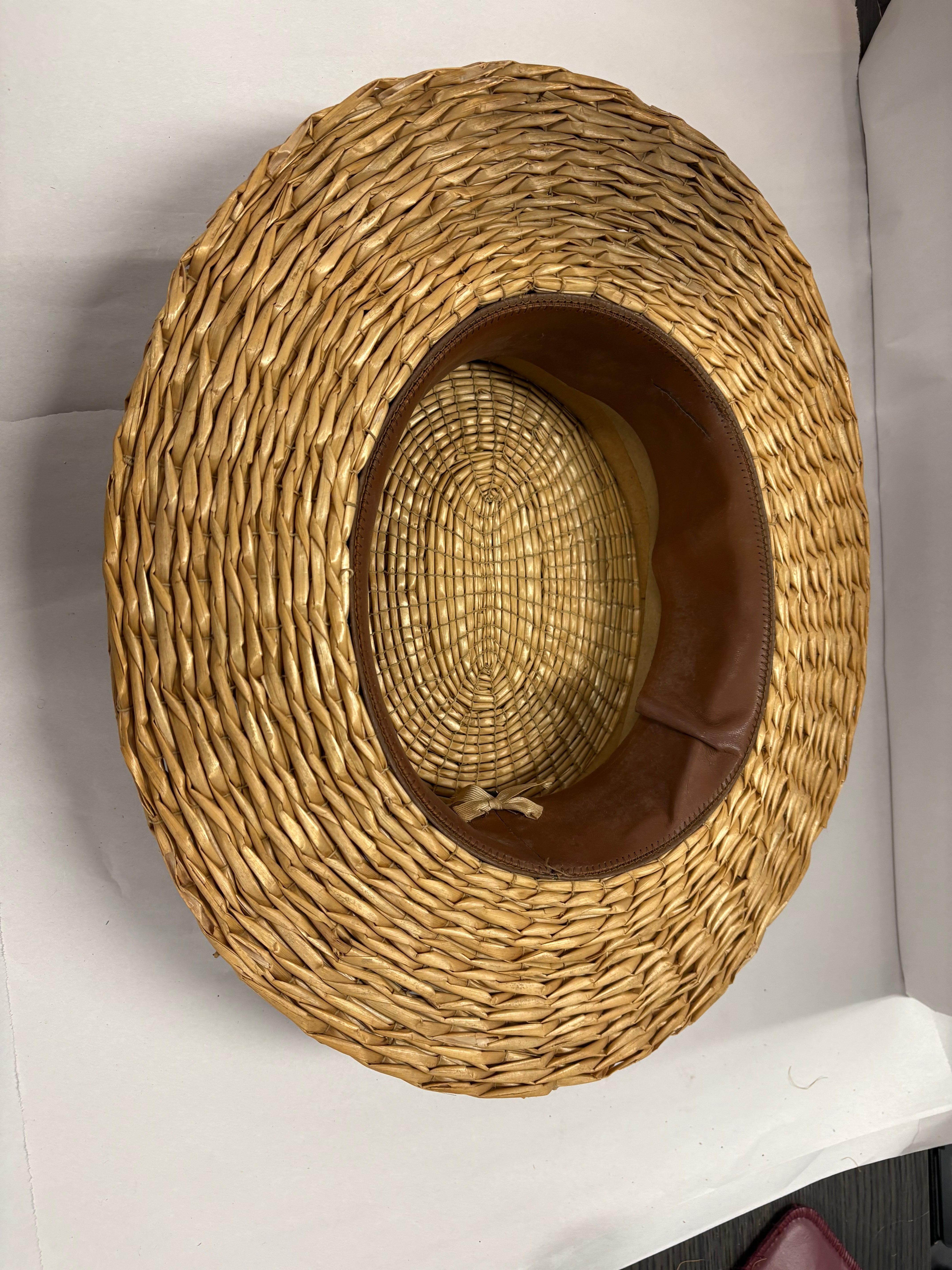 Antique straw boater hat with a black band and bow