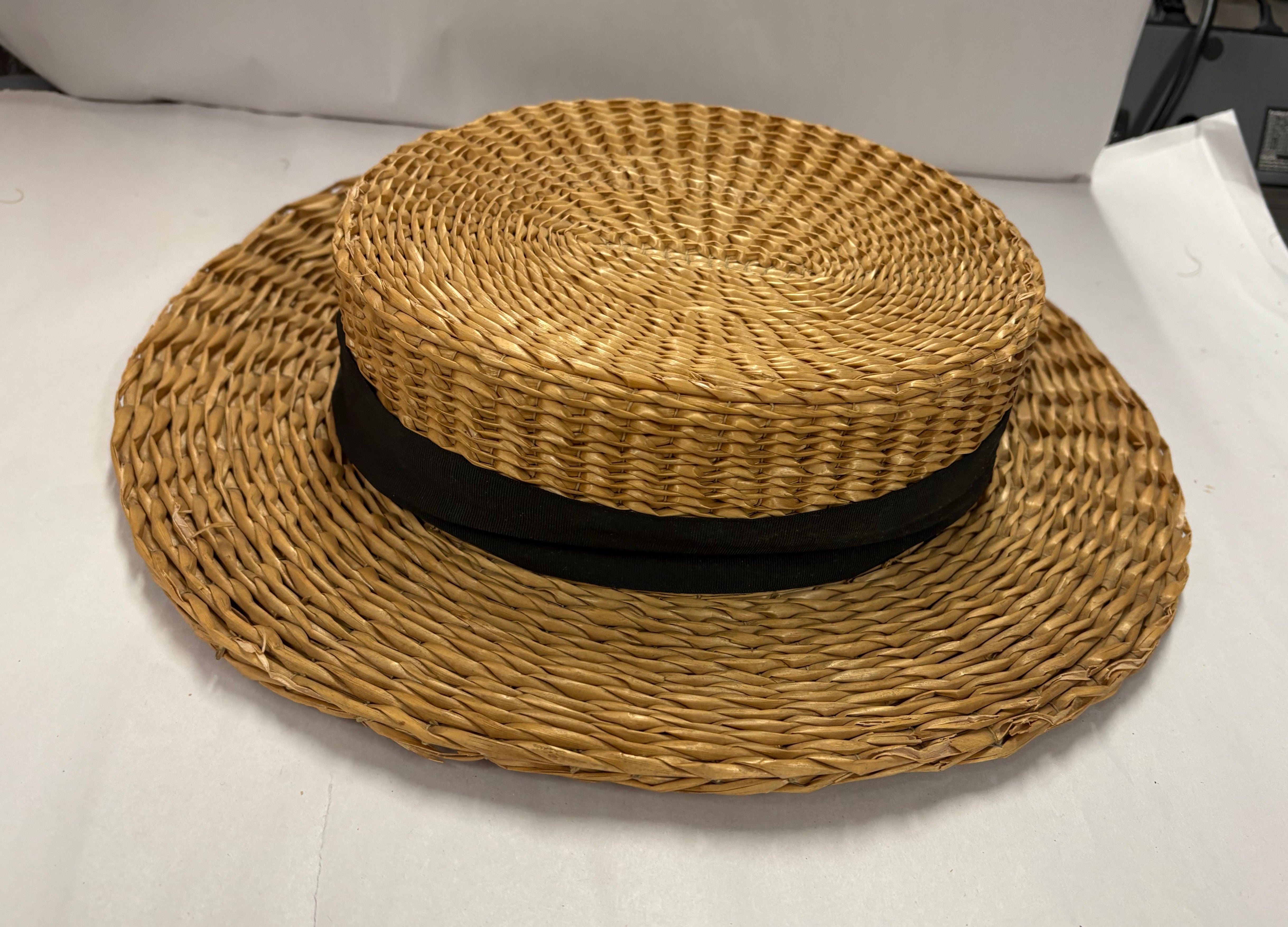 Antique straw boater hat with a black band and bow