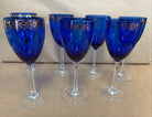 set of 7 stemmed blue goblets with a gold band along the rim