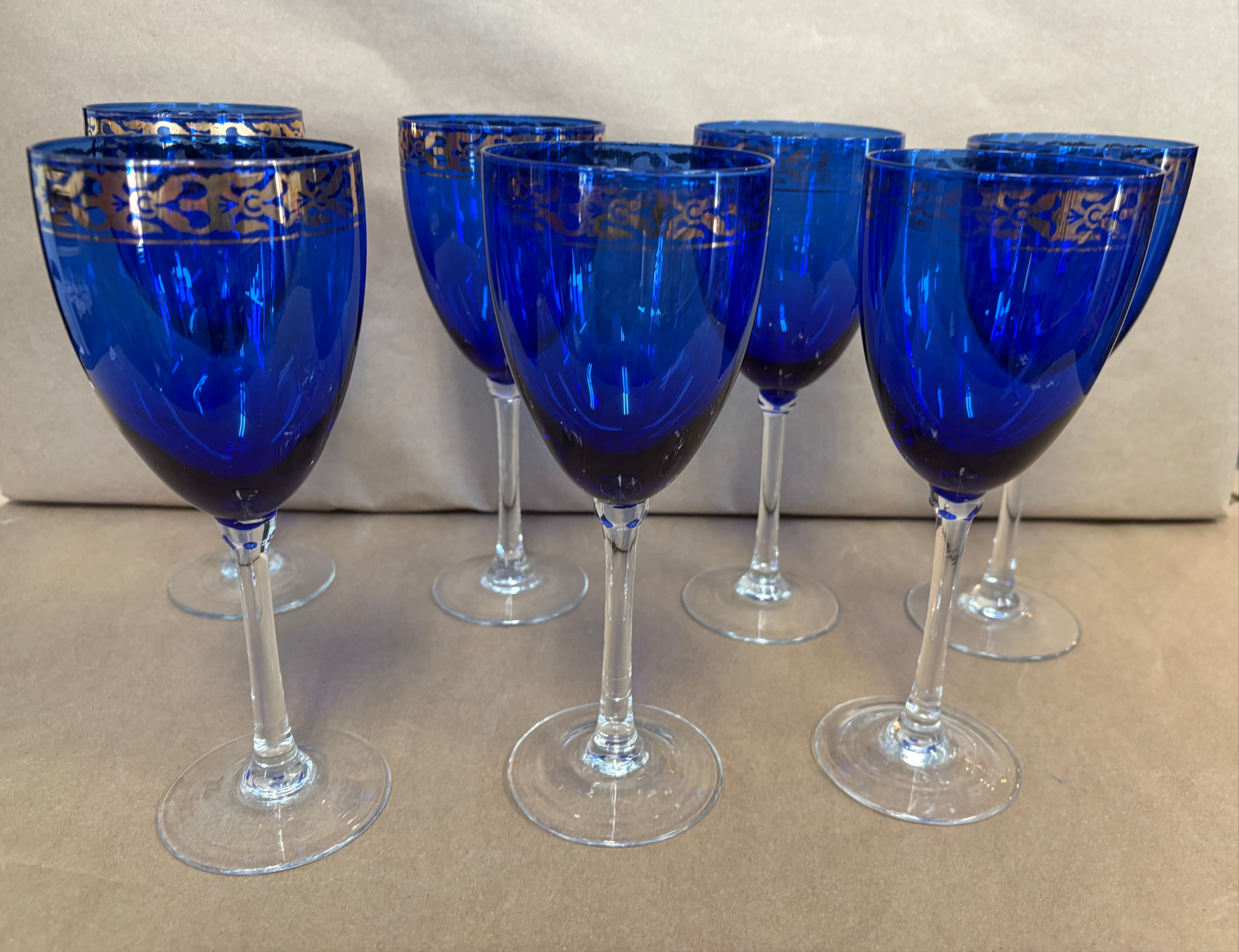 set of 7 stemmed blue goblets with a gold band along the rim