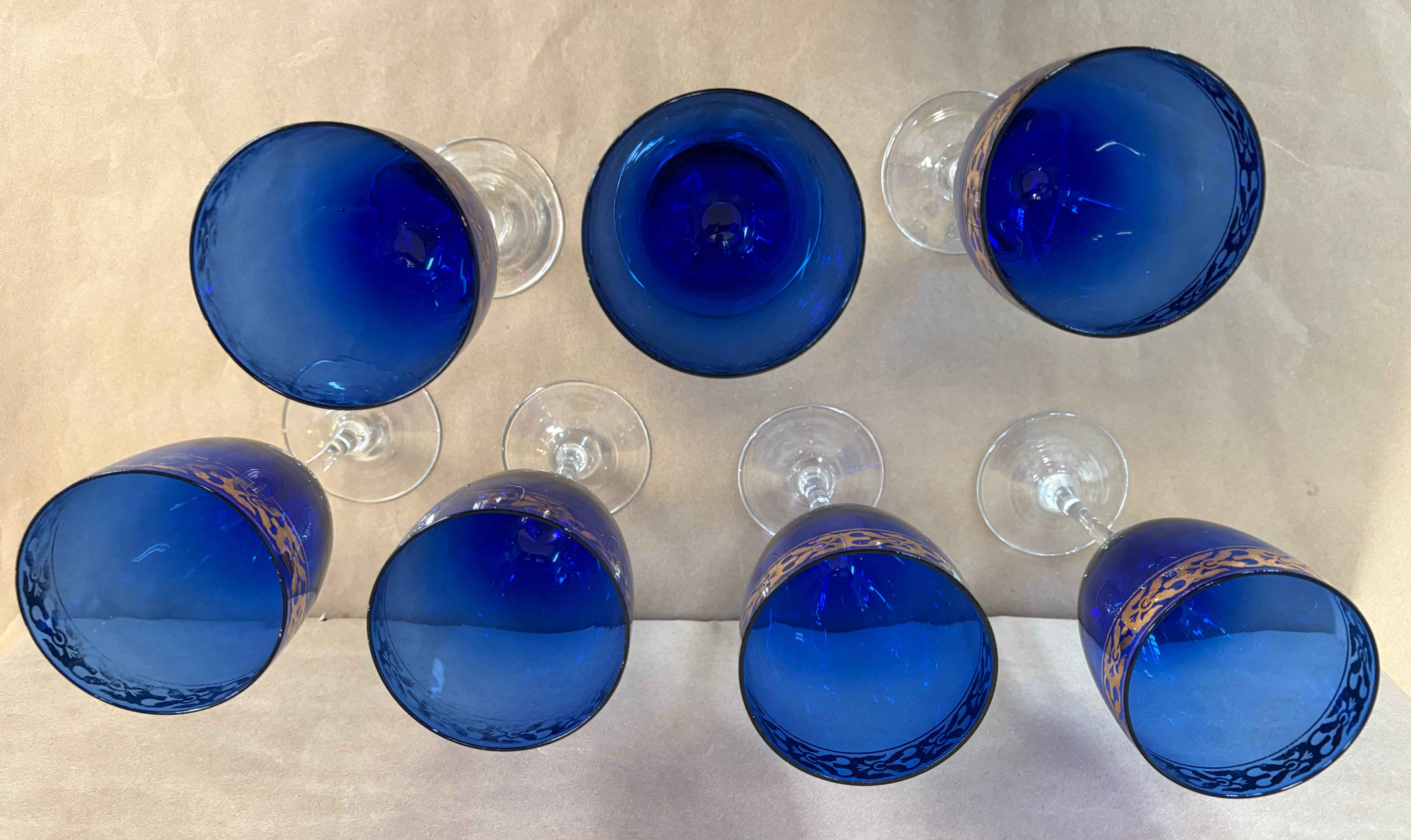 set of 7 stemmed blue goblets with a gold band along the rim