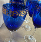 set of 7 stemmed blue goblets with a gold band along the rim
