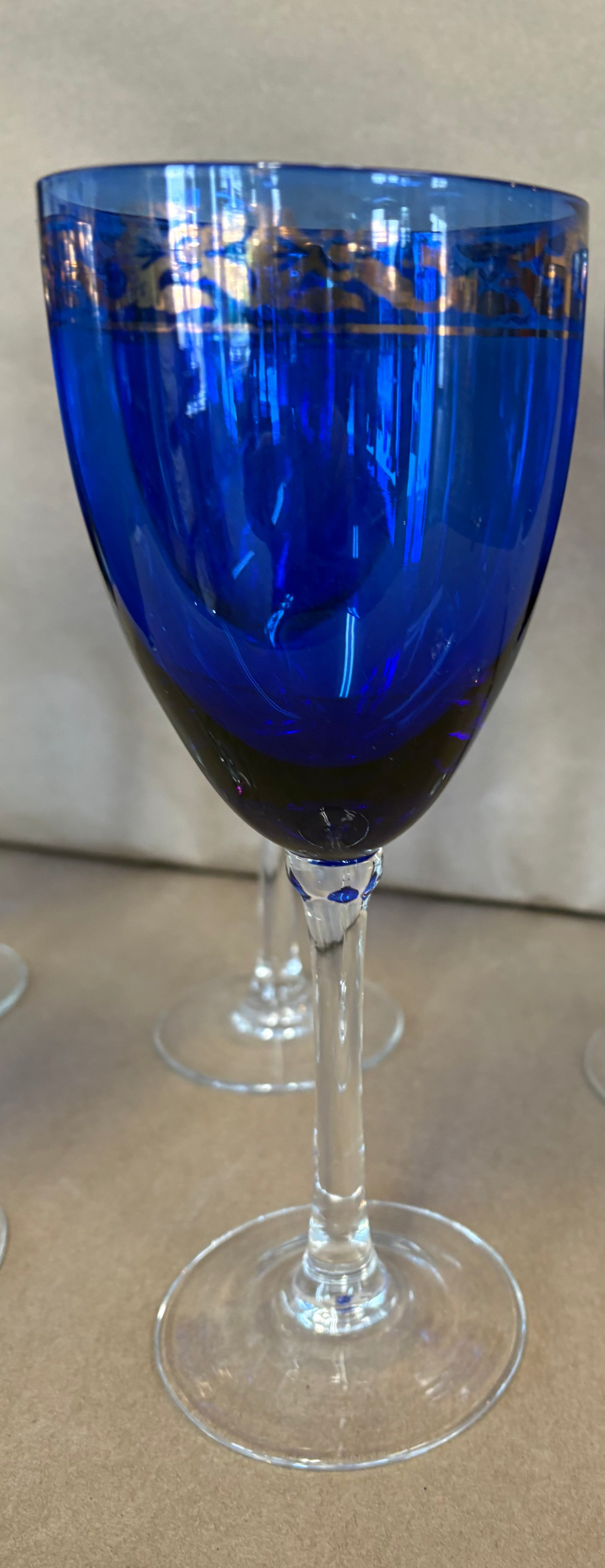 set of 7 stemmed blue goblets with a gold band along the rim