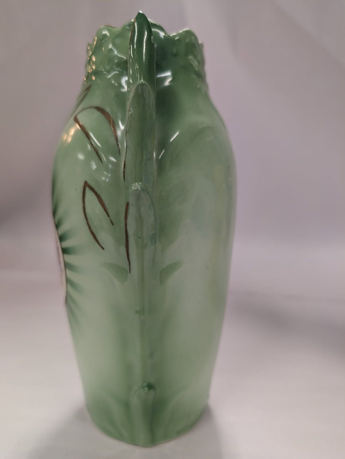 Czechoslovakian green vase with a bird on a swing amidst flowers