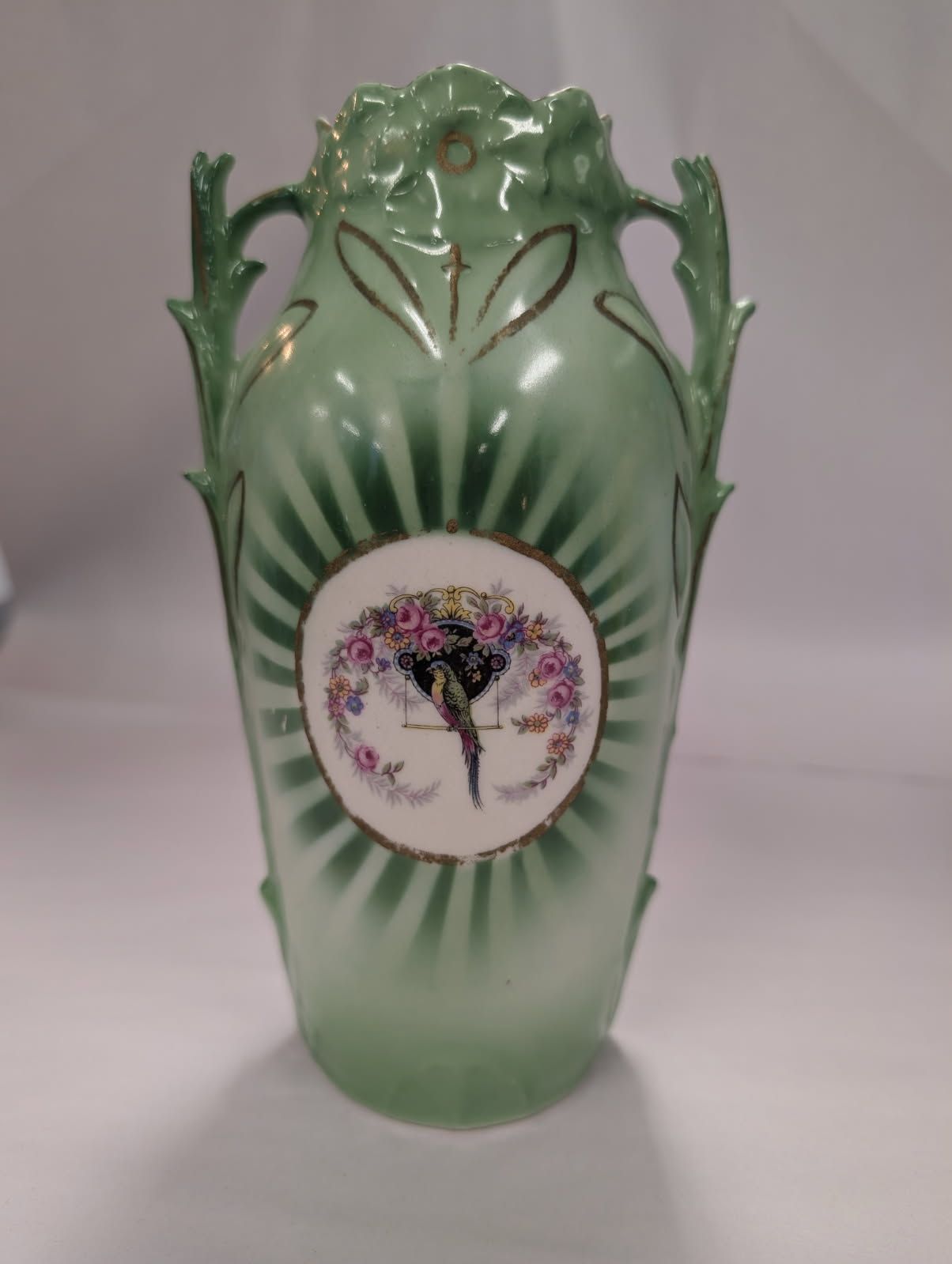 Czechoslovakian green vase with a bird on a swing amidst flowers